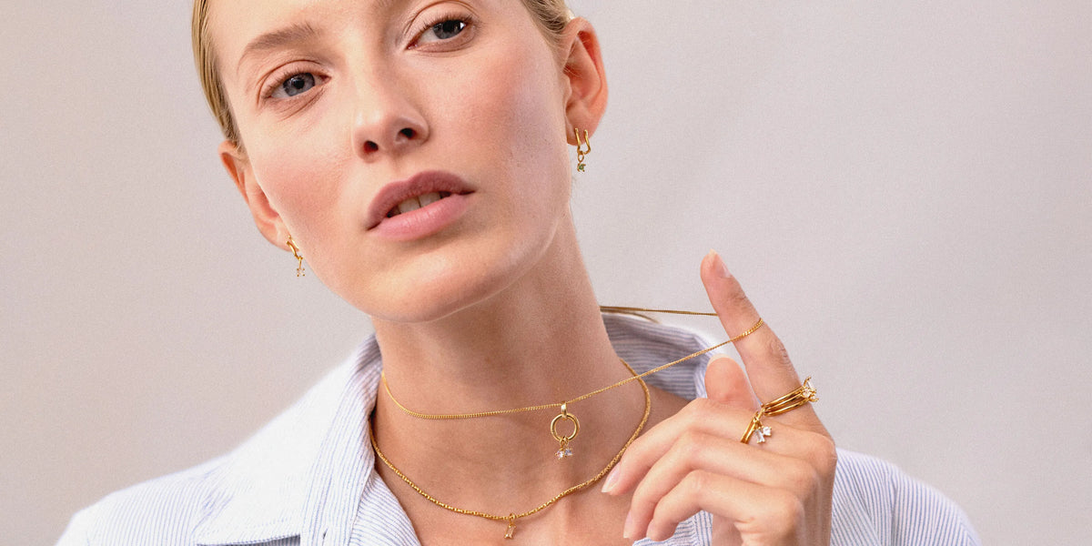 Model trägt Stilnest Light Play Ohrringe, Ketten und Ringe mit bunten Edelsteinen