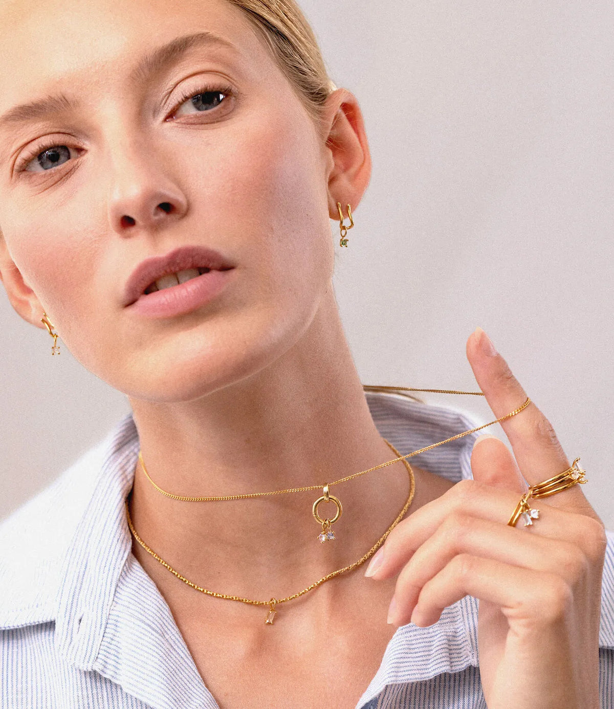 Model trägt Stilnest Light Play Ohrringe, Ketten und Ringe mit bunten Edelsteinen